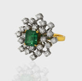 Ring, a captivating union of elegance and luxury, adorned with a stunning Emerald embraced by shimmering Diamonds.(PGDR0416)