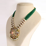 Featuring a handcrafted pendant with layered polki and diamond detailing, accented by rose quartz, emeralds, and rubies, paired with emerald bead strings and South Sea pearls for a regal finish. (GDNE0515)