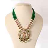 Featuring a handcrafted pendant with layered polki and diamond detailing, accented by rose quartz, emeralds, and rubies, paired with emerald bead strings and South Sea pearls for a regal finish. (GDNE0515)