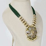 Featuring a handcrafted pendant with layered polki and diamond detailing, accented by rose quartz, emeralds, and rubies, paired with emerald bead strings and South Sea pearls for a regal finish. (GDNE0515)