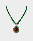 A captivating pendant featuring a ruby cabochon encircled by emerald-cut ovals and diamonds, strung with emerald beads for a bold fusion of colour, brilliance, and timeless luxury. (GDPE0408)