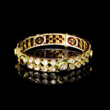 Traditional Jadau bangle adorned with uncut polki diamonds, teardrop motifs, and striking green enamel detailing. A timeless piece reflecting regal Rajasthani craftsmanship and heritage elegance.(KMB0513)