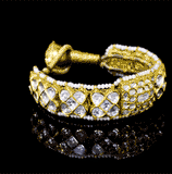 Luxurious handcrafted gold Pounchi Bangle adorned with intricate polki diamond floral motifs and bordered with delicate pearls. A perfect blend of traditional artistry and royal elegance.(KMB0581)
