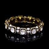 Elegant antique gold bangle featuring large square polki diamonds accented with fine detailing. A timeless piece that reflects royal heritage and impeccable craftsmanship for special occasions.(KMB0586)