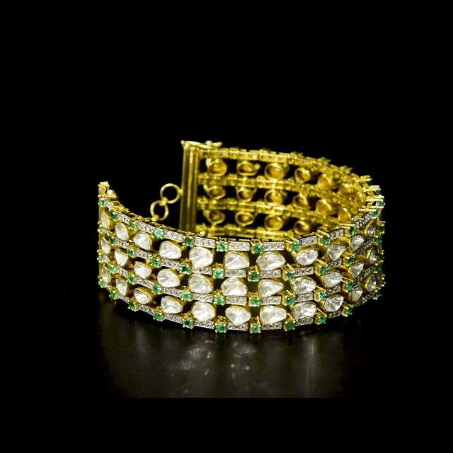 Versatile gold choker cum bracelet adorned with shimmering round diamonds, uncut diamond polki, and vibrant oval emerald accents, crafted in layered elegance to create a bold, luxurious statement for contemporary and traditional looks. (KMBR0150)