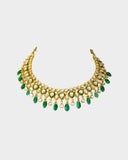 An elegant necklace and earring set featuring diamond polki framed by a vivid green circle, strung with emerald maniya and pearls. Blending heritage craftsmanship with refined luxury, it’s perfect for graceful, modern celebrations. (KMNE3588)