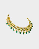 An elegant necklace and earring set featuring diamond polki framed by a vivid green circle, strung with emerald maniya and pearls. Blending heritage craftsmanship with refined luxury, it’s perfect for graceful, modern celebrations. (KMNE3588)