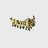 Embrace timeless elegance with this green Meena choker necklace and tops set, featuring sparkling uncut diamond polki, strung with vibrant emerald maniya and delicate pearls. Perfect for adding royal charm to any festive or bridal look.(KMNE3604)
