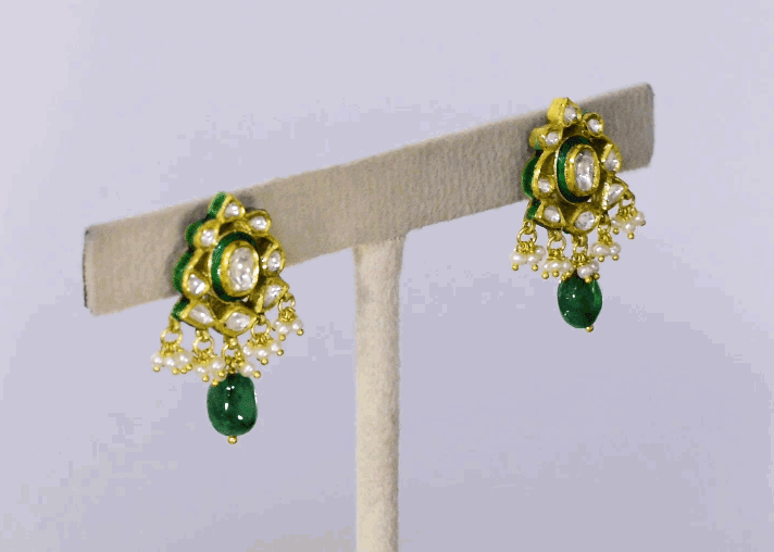 Embrace timeless elegance with this green Meena choker necklace and tops set, featuring sparkling uncut diamond polki, strung with vibrant emerald maniya and delicate pearls. Perfect for adding royal charm to any festive or bridal look.(KMNE3604)