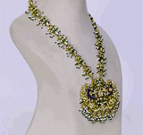 Celebrate tradition with this vibrant multi-color enameled long necklace and earring pair, adorned with uncut diamonds and pearls. Featuring intricate fish design links and a majestic peacock pendant. (KMNE3605)