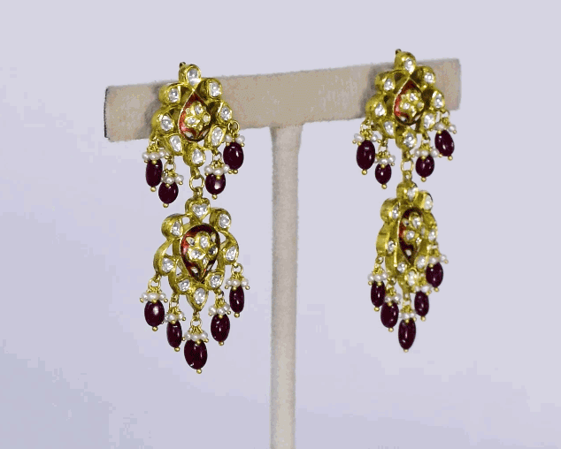 Beautiful red enameled flower design necklace and earrings set with sparkling uncut diamond polki, strung with ruby maniya and pearls. Perfect to add a touch of tradition and elegance to any special occasion.(KMNE3608)