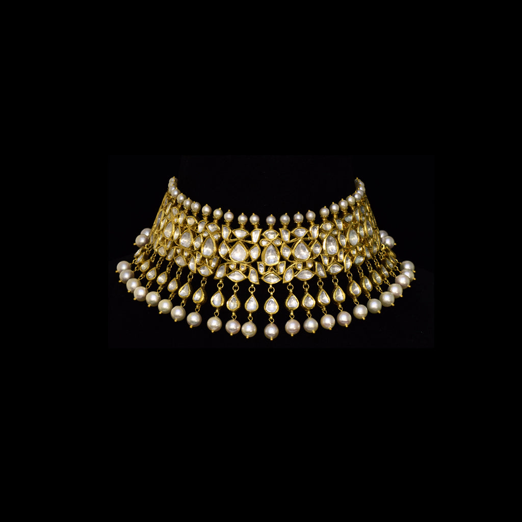 Elevate your style with this stunning semi-choker necklace and earring pair, featuring dazzling uncut diamond polki and a striking larger center stone, beautifully strung with pearls. Perfect for adding royal charm to any special occasion.(KMNE3611)