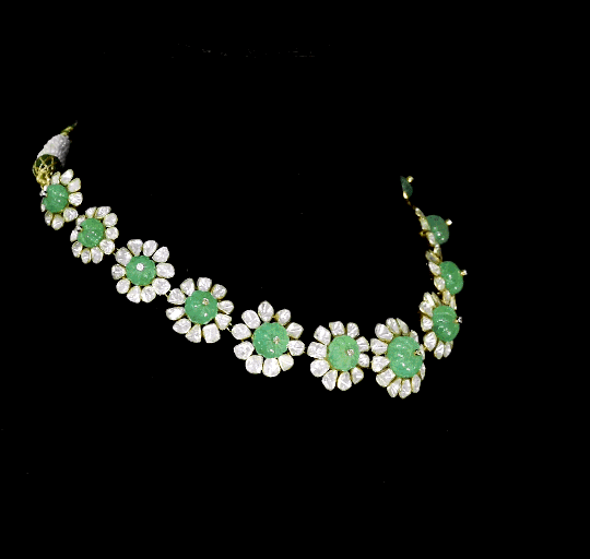 Discover refined elegance with this fusion-style necklace set, featuring a carved emerald centerpiece surrounded by uncut diamond Polki. A perfect harmony of tradition and modernity, crafted to make a statement.(KMNE3614)