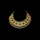 Make a majestic statement with this grand necklace set, featuring uncut diamond Polki, a striking emerald centerpiece, rich red stones, and delicate pearls in the funghar. A masterpiece of regal elegance.(KMNE3616)
