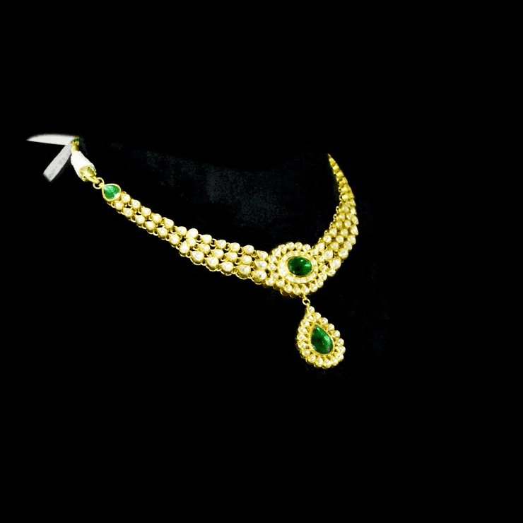This exquisite set features luminous polki diamonds highlighted by rich green stones, embodying heritage craftsmanship and royal charm. (KMNE3675)