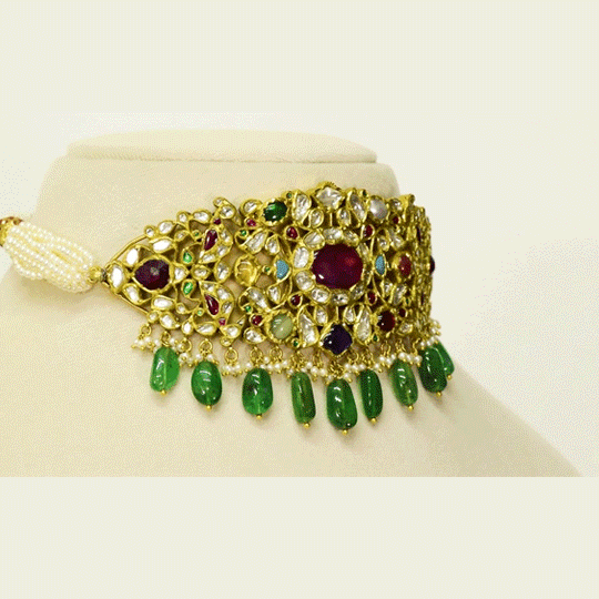 A regal Navratan stiff choker adorned with hand-set diamond polki and vibrant coloured stones, finished with emerald maniya and pearl stringing. A timeless statement of heritage craftsmanship and royal elegance. (KMNE3690)