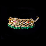 A fusion Navratan choker featuring polki diamonds in gold, highlighted with a central ruby, multicolored gemstones, intricate pearl detailing, and cascading emerald drops—paired with statement earrings for a rich, regal presence. (KMNE3719)