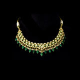 A stunning necklace set with gold and diamond polki, featuring green enamelled detailing, accented with emerald maniya drops and delicate pearls, creating a perfect blend of heritage elegance and vibrant sophistication. (KMNE3732)