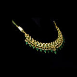 A stunning necklace set with gold and diamond polki, featuring green enamelled detailing, accented with emerald maniya drops and delicate pearls, creating a perfect blend of heritage elegance and vibrant sophistication. (KMNE3732)