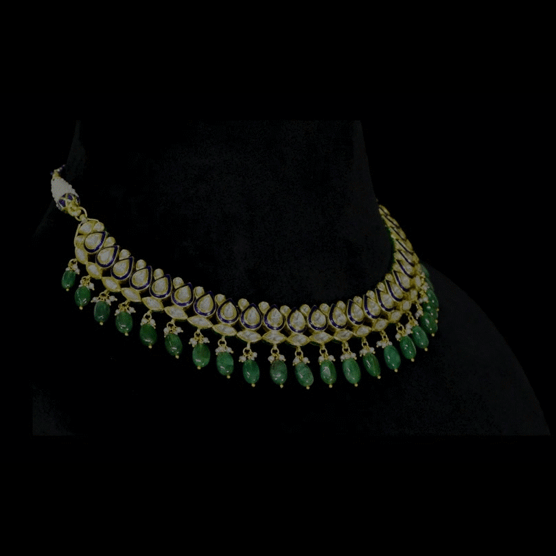 An elegant gold necklace set featuring polki diamonds with blue enamel detailing, accented by emerald maniya and delicate pearl hangings, offering a graceful blend of tradition and refined contemporary luxury. (KMNE3739)