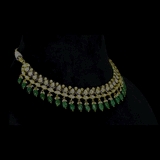 An elegant gold necklace set featuring polki diamonds with blue enamel detailing, accented by emerald maniya and delicate pearl hangings, offering a graceful blend of tradition and refined contemporary luxury. (KMNE3739)
