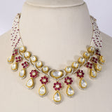 A graceful fusion necklace with diamond polki, round diamonds, vibrant rubies, and elegant pearl stringing, paired with matching earrings for timeless sophistication and charm.(KMNE3759)