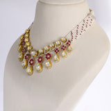 A graceful fusion necklace with diamond polki, round diamonds, vibrant rubies, and elegant pearl stringing, paired with matching earrings for timeless sophistication and charm.(KMNE3759)