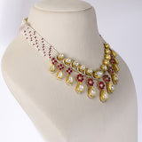 A graceful fusion necklace with diamond polki, round diamonds, vibrant rubies, and elegant pearl stringing, paired with matching earrings for timeless sophistication and charm.(KMNE3759)