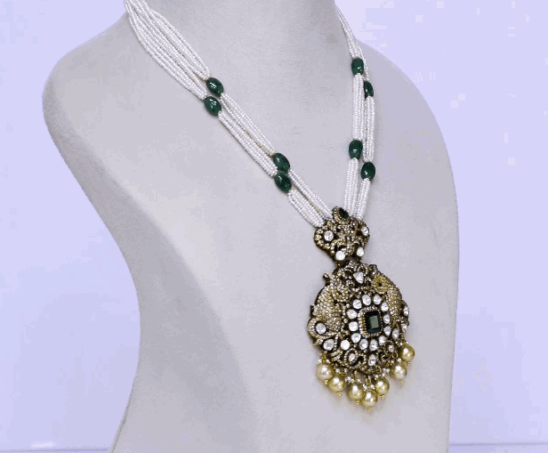Discover refined elegance with this fusion-style pendant, showcasing uncut diamond Polki, round diamonds, and a central emerald. Strung with pearls and long emerald beads, it’s a striking blend of tradition and modern sophistication.(KMPE1327)