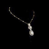 Featuring hand-set polki diamonds with shimmering diamond halos and a gold chain adorned with pearls, this pendant is a masterpiece of heritage luxury. (KMPE1384)