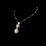 Featuring hand-set polki diamonds with shimmering diamond halos and a gold chain adorned with pearls, this pendant is a masterpiece of heritage luxury. (KMPE1384)