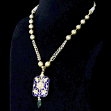 Blue Meenakari Pendant Set Elegant blue meenakari pendant set adorned with diamond polki, gracefully strung with pearls and emerald accents, blending timeless artistry with refined elegance.(KMPE1397)