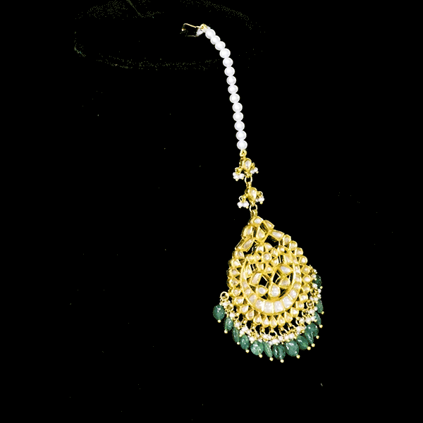 Adorn your look with this elegant Ekposta Maangtika featuring uncut diamond Polki, beautifully strung with emerald maniya and pearls.(KMTK0226)
