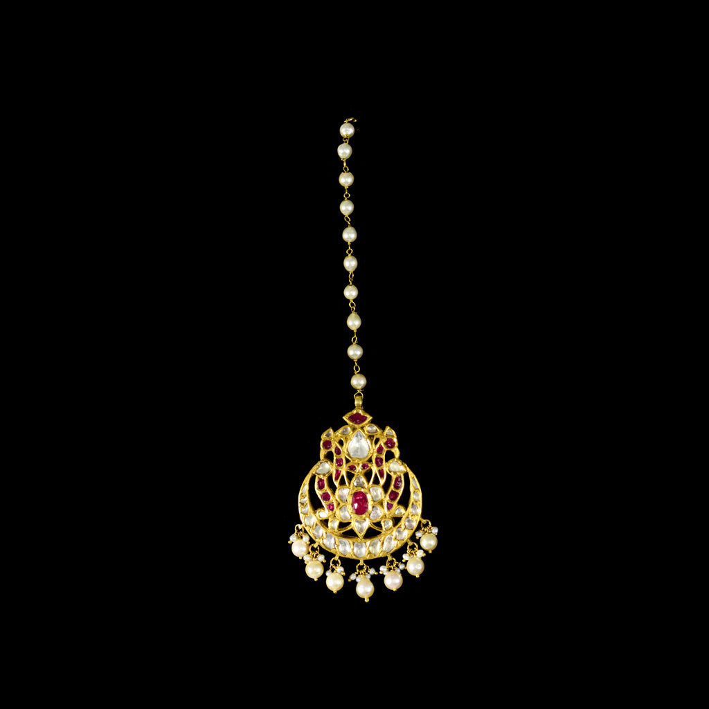 Enhance your bridal charm with this stunning maangtika, featuring uncut diamonds and vibrant rubies, beautifully strung with pearls.(KMTK0227)
