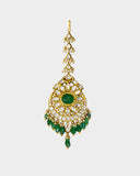 A regal maangtika adorned with diamond polki and a radiant emerald centre, finished with emerald and pearl stringing for timeless elegance and traditional bridal charm. (KMTK0243)