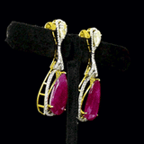 Ruby & Diamond Drop Earrings Graceful drop earrings showcasing vibrant pear-shaped rubies, accented with brilliant round diamonds and elegant pear-cut diamonds for timeless sophistication and brilliance.(PGDE0451)