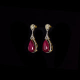 Ruby & Diamond Drop Earrings Graceful drop earrings showcasing vibrant pear-shaped rubies, accented with brilliant round diamonds and elegant pear-cut diamonds for timeless sophistication and brilliance.(PGDE0451)