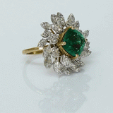 A fine emerald centerpiece surrounded by sparkling diamonds, creating a graceful ring that radiates timeless elegance and brilliance.(PGDR0460)