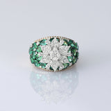 Featuring a sparkling diamond flower centerpiece surrounded by rich green emeralds, this ring is a true symbol of refined elegance. (PGDR0516)