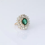 A vibrant emerald centerpiece surrounded by sparkling diamonds, creating a graceful ring filled with timeless elegance and charm.(PGDR0520)