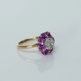 A radiant round diamond embraced by a halo of vivid pink sapphires—where timeless brilliance meets feminine charm. (PGDR0524)